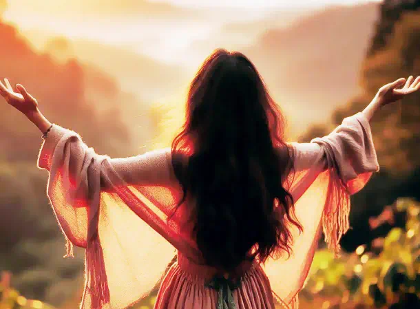 Mujer dando gracias al cielo en puesta de sol