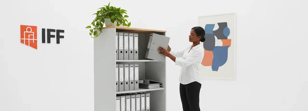 mujer colocando archivadores en mueble estanteria de oficina | archivadores